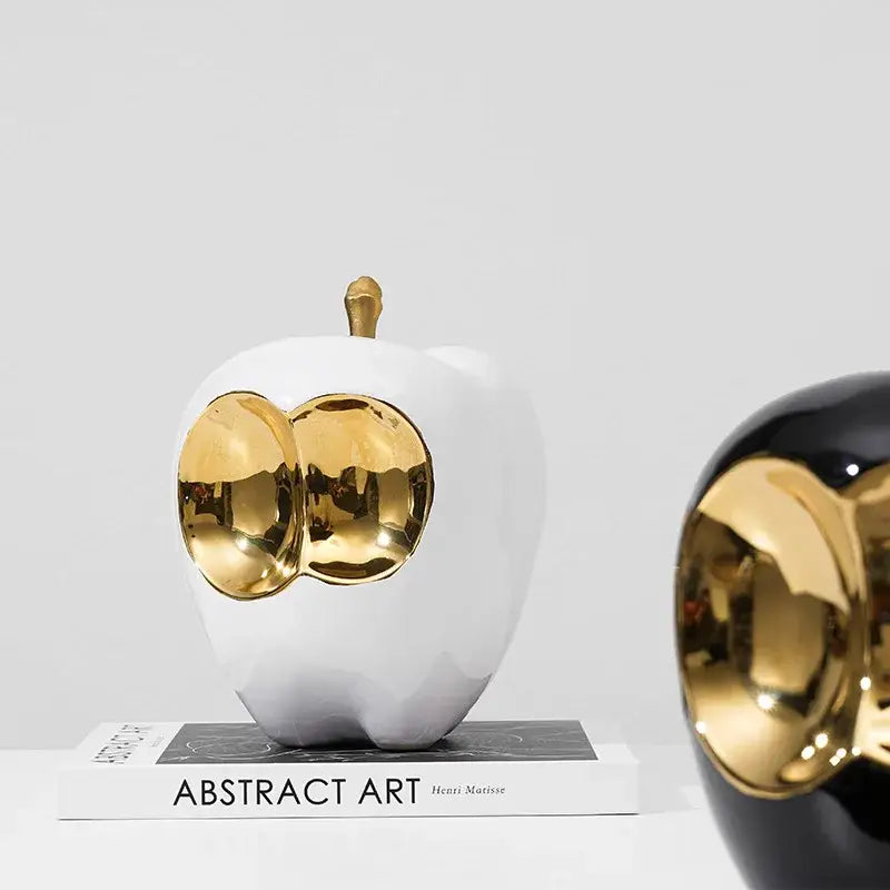 Abstract white and gold ceramic apple sculpture with golden cheeks and stem for living room decor