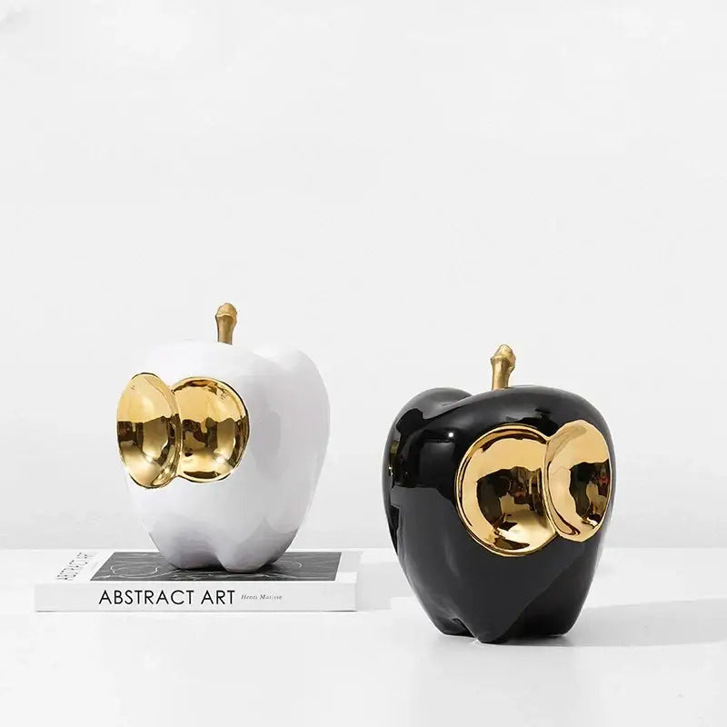 Abstract white and black ceramic apple sculpture with golden apple stems and accents for living room decor