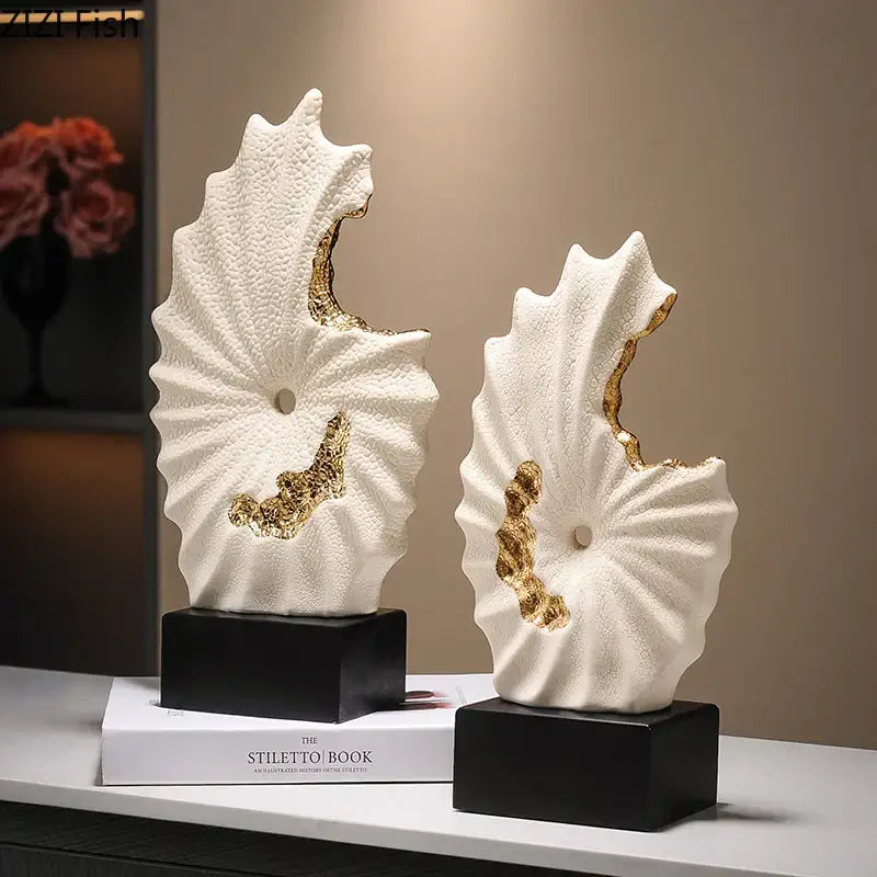 Abstract white and gold gilded ceramic landscape sculptures resembling stylized seashells for living room decor