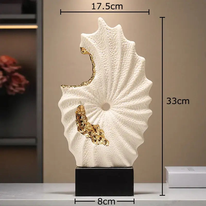 Abstract white and gold gilded ceramic landscape seashell sculpture with gold leaf accents on a black base for living room decor