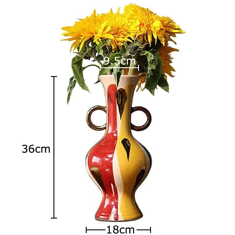 A vibrant ceramic vase plant with red and yellow split design, dark brown handles, and abstract black markings for living room decor
