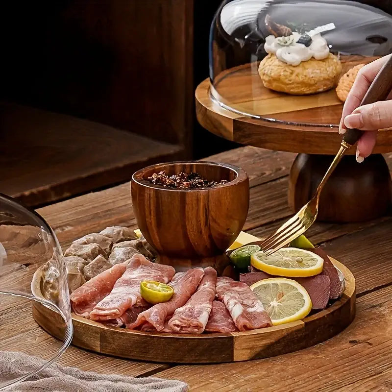Wooden serving platter with sliced meats lemon slices and dark seasoning on decorbites acacia wood cake stand with glass dome