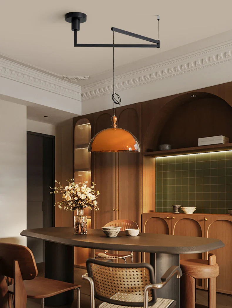 Warm amber glass acrylic pendant light with dark wood lampshade and black metal arm fixture for elegant lighting