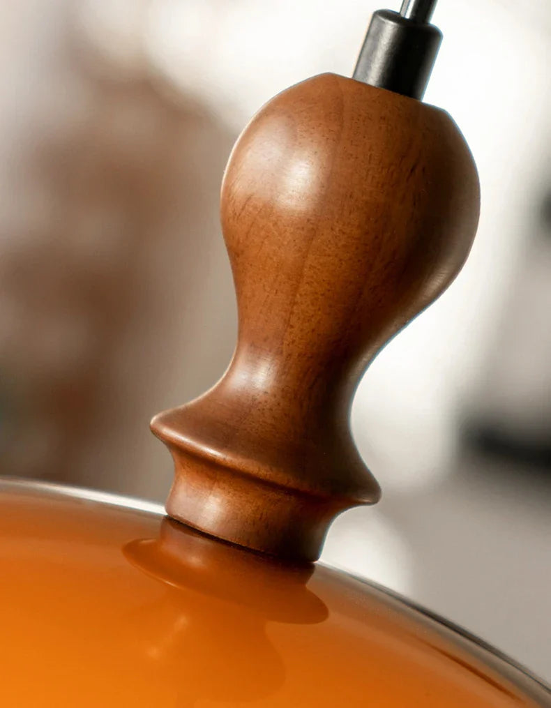 Acrylic pendant light with a polished dark wood lampshade knob featuring warm tones and subtle grain patterns