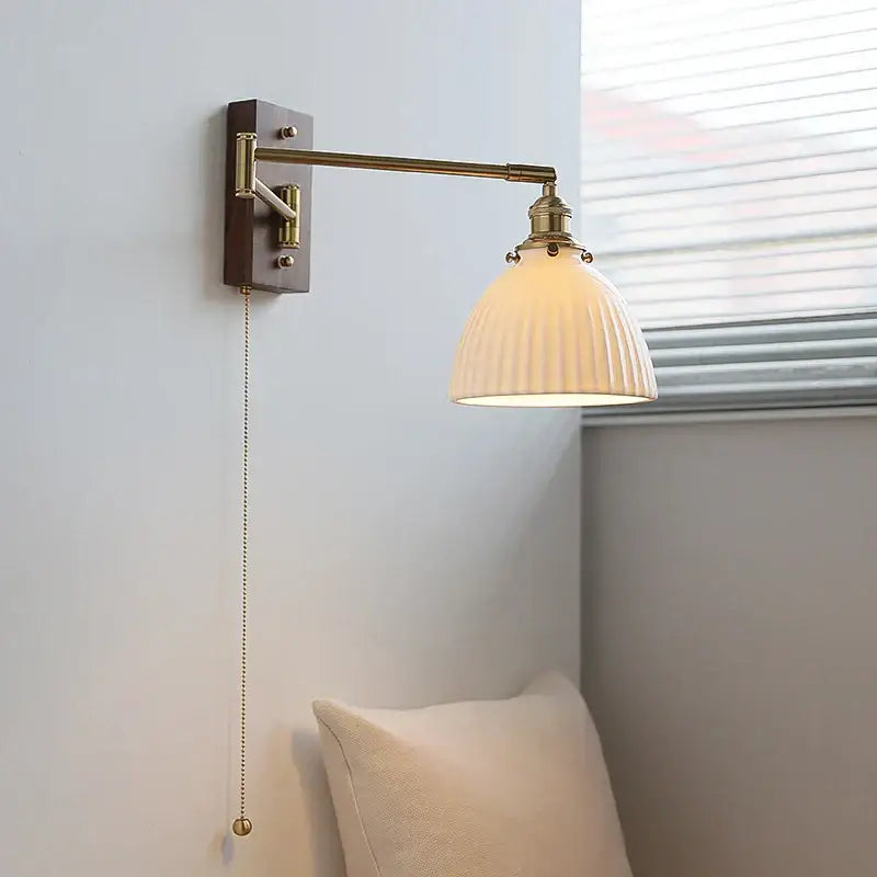 Adjustable brass wall sconce with copper arm, ribbed cream glass shade, and wooden backplate for bedroom decorbites lighting