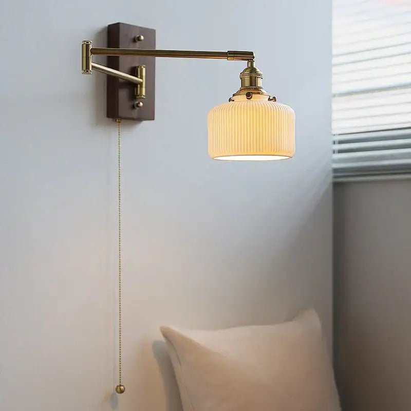 Adjustable brass wall sconce with copper arm and ribbed off-white glass shade for bedroom decorbites lighting