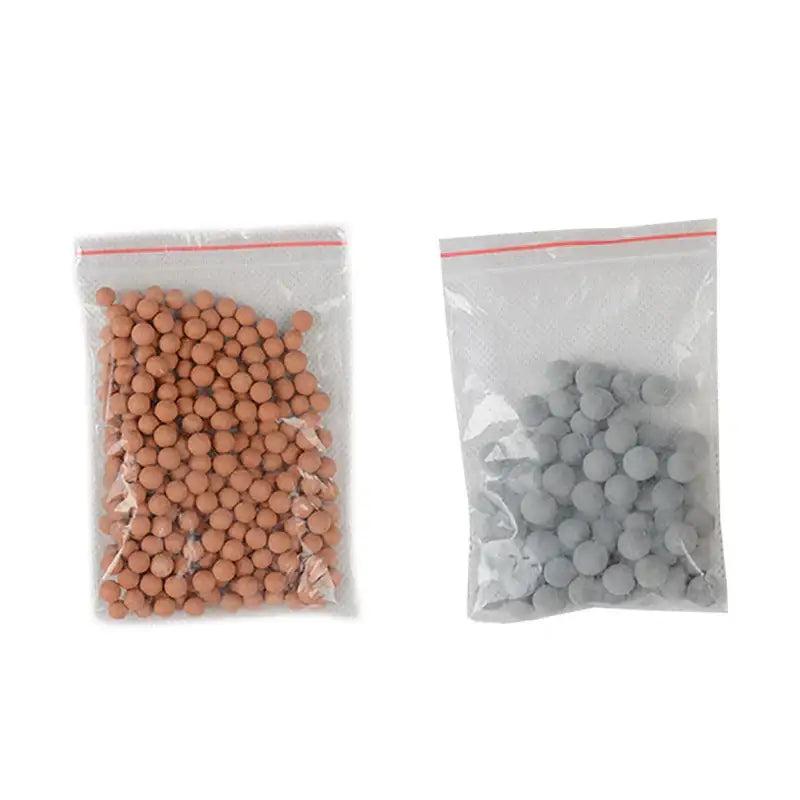 Two clear bags with tan and gray filter beads for an adjustable shower head with chrome accents and filter function
