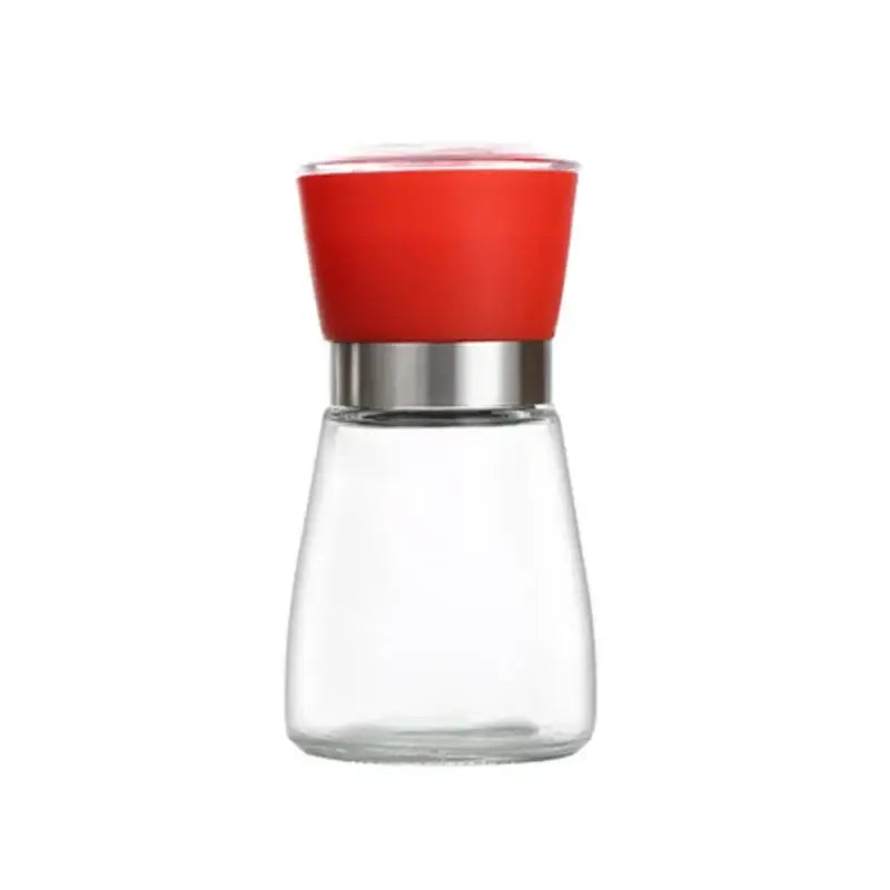 Clear glass adjustable spice grinder with vibrant red silicone top and stainless steel band for kitchen use
