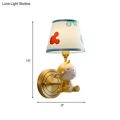 Adorable lámpara de pared con forma de mono de dibujos animados, con estructura de latón y pantalla de tela.