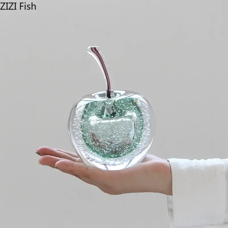 Clear glass cherry ornament with green and white bubbles and dark red stem as a glass fruit sculpture desk ornament