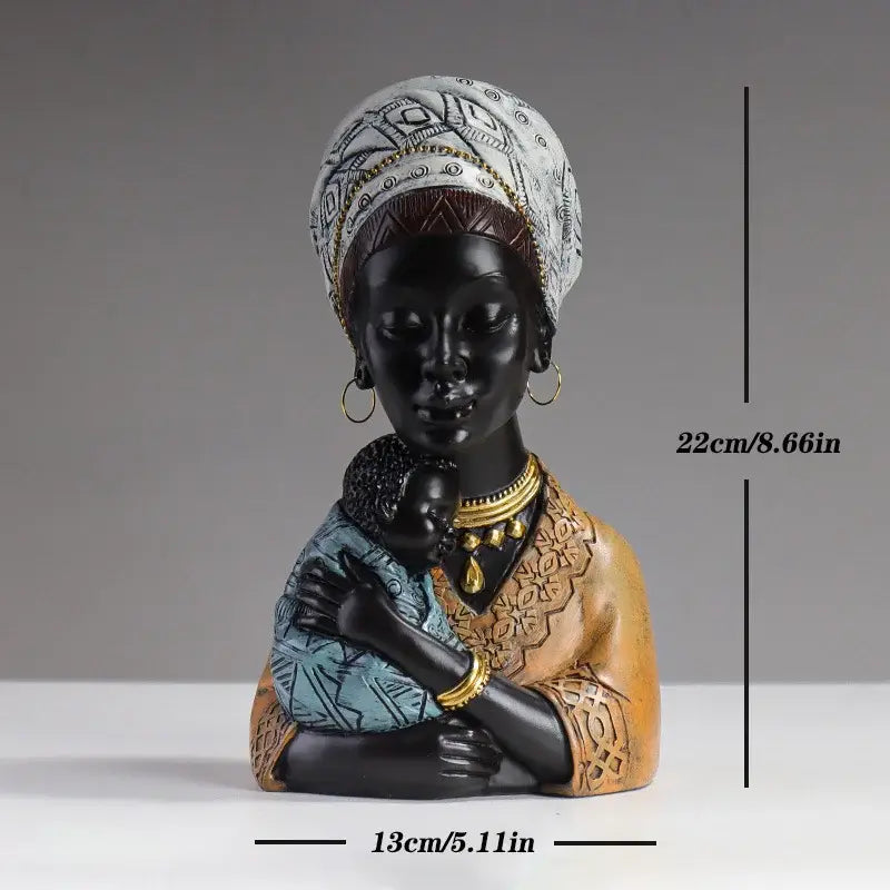 A glossy black resin african mother child abstract bust with a patterned white headwrap and gold trimmed jewelry decorbites decor