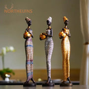Three black woman resin figurines with gold accents holding bowls in african style decorbites living room decor