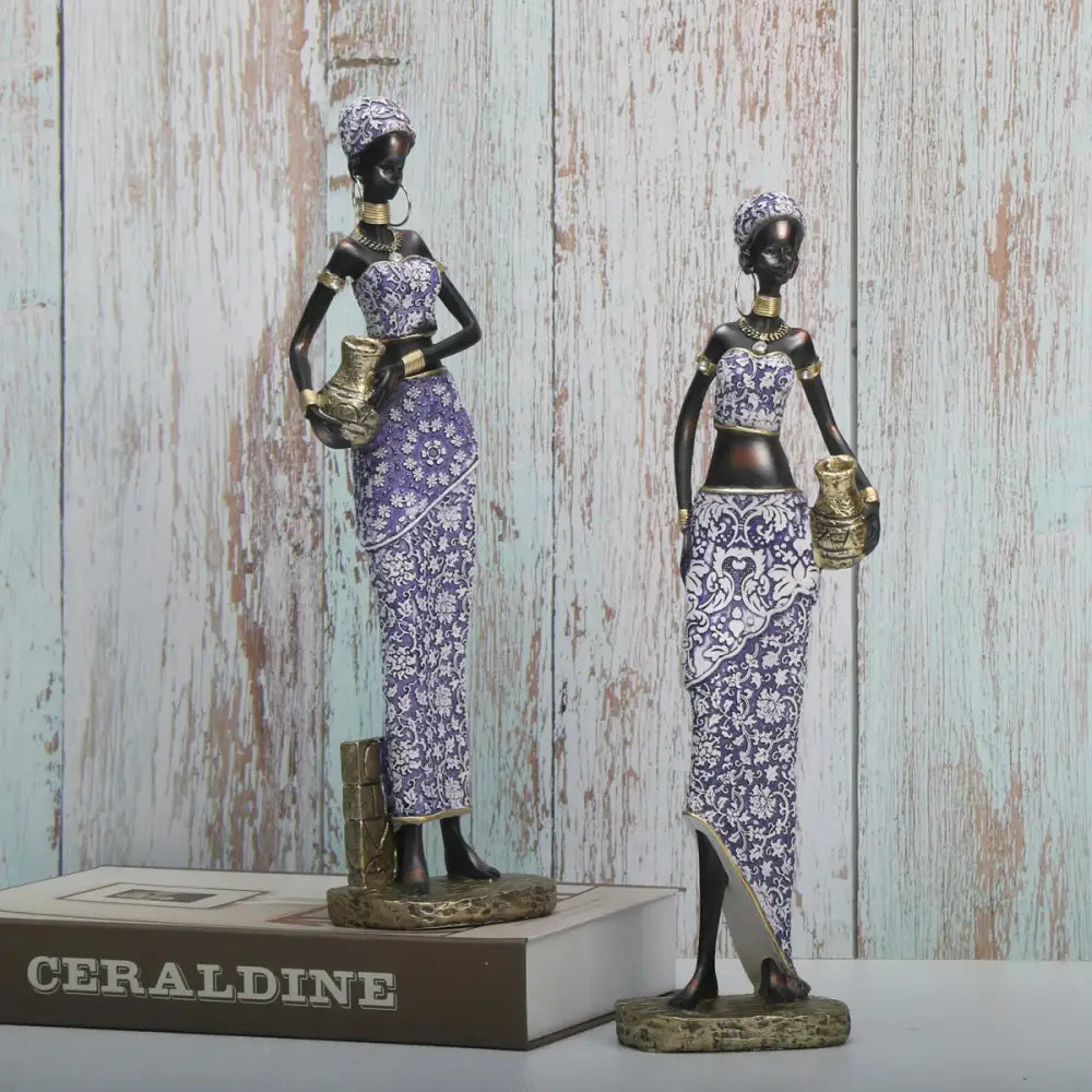 Two elegant african woman sculptures in purple and white patterned dresses with gold accents for living room decorbites decor