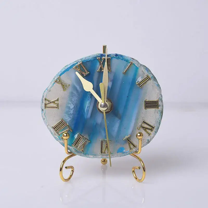 A blue agate stone clock with gold roman numerals and hands on a decorative golden stand for luxury decorbites decor
