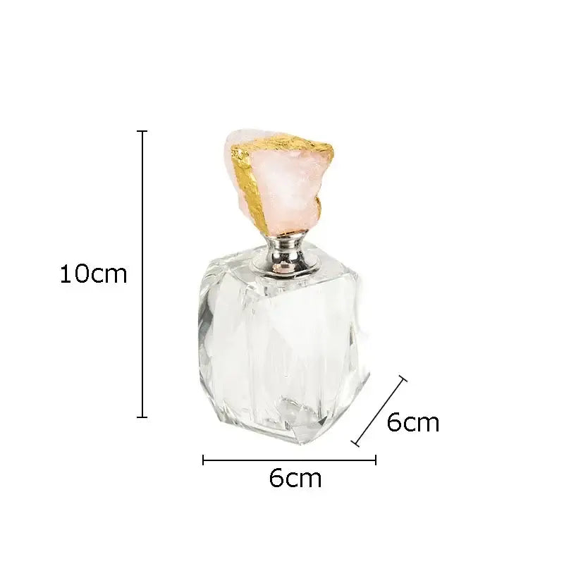 A clear faceted glass agate stone perfume bottle with a pink rose quartz stopper for essential oils bedroom decor
