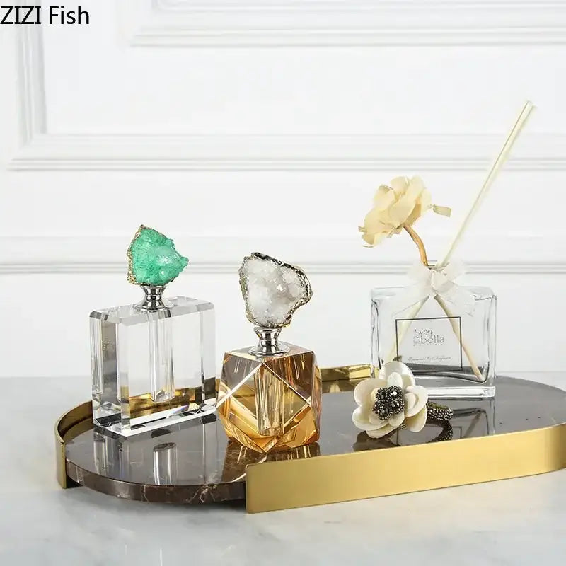 Two crystal agate stone perfume bottles with green and white geode stoppers for essential oils on gold tray