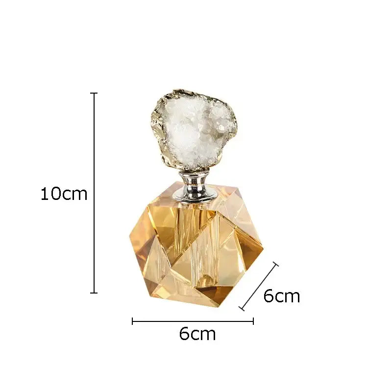 A faceted amber glass agate stone perfume bottle with silver metal neck and white geode stopper for essential oils