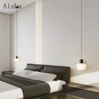 Modern white layered pendant light with black fixtures featuring decorbites acrylic led hanging above a sleek bed