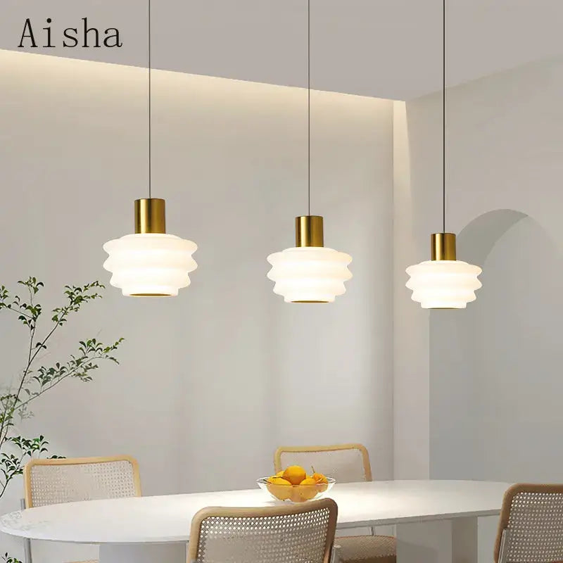 Three elegant gold Aisha pendant lights with layered frosted glass shades for bedroom decor and acrylic led hanging