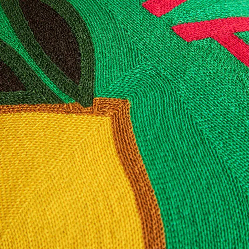 Vibrant green and yellow knitted cushion cover with bold embroidered lemon design and red accents for living room