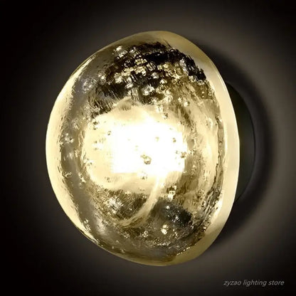 A warm amber and gold textured crystal led wall lamp with swirling glass shade from decorbites for bedroom decor
