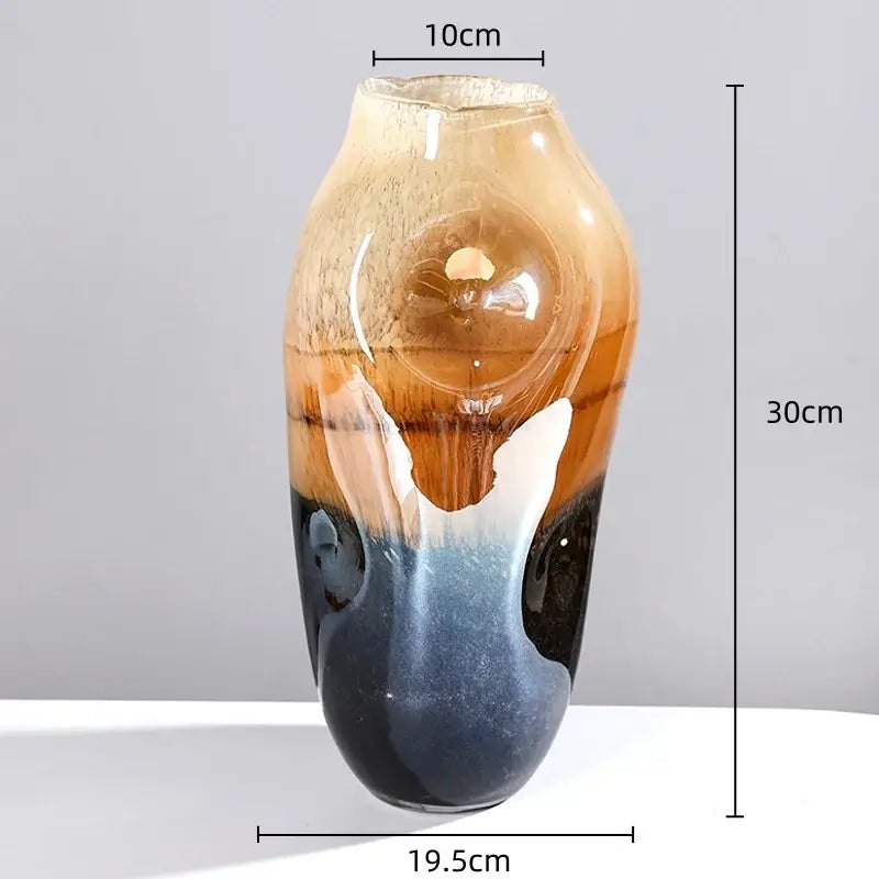 A tall slender decorbites gradient glass vase with amber to deep blue hues and white swirls for irregular floral arrangement