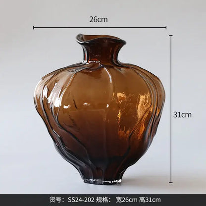 A glossy amber brown wavy grain glass pumpkin vase with a fluted shape and irregular rim for living room decor