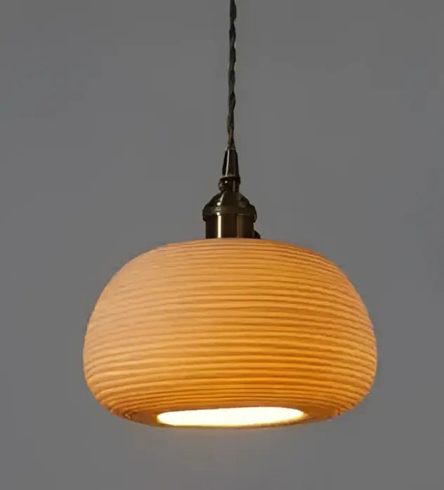 Amber and cream geometric glass pendant light with warm-toned ribbed ceramic and brass fixture for dining room