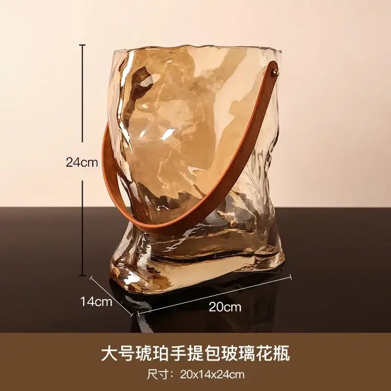 Translucent amber bag shape glass vase with crinkled texture and brown leather handle for living room decor