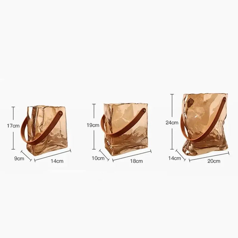 Transparent amber-colored crinkled bag shape glass vases with brown leather handles in three sizes for living room decor