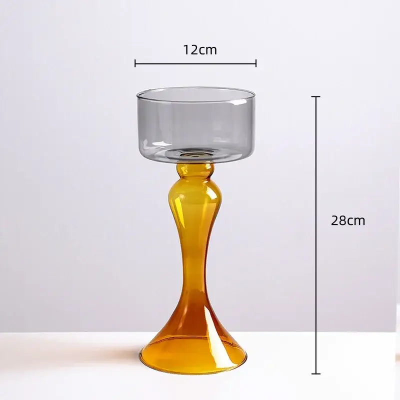 A tall slender amber decorbites geometric glass candle holder with a translucent base and clear cylindrical vase bowl