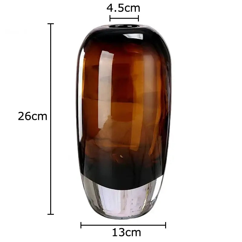 A tall sleek decorbites delicate glass vase with amber to dark brown gradient and clear base for living room decor