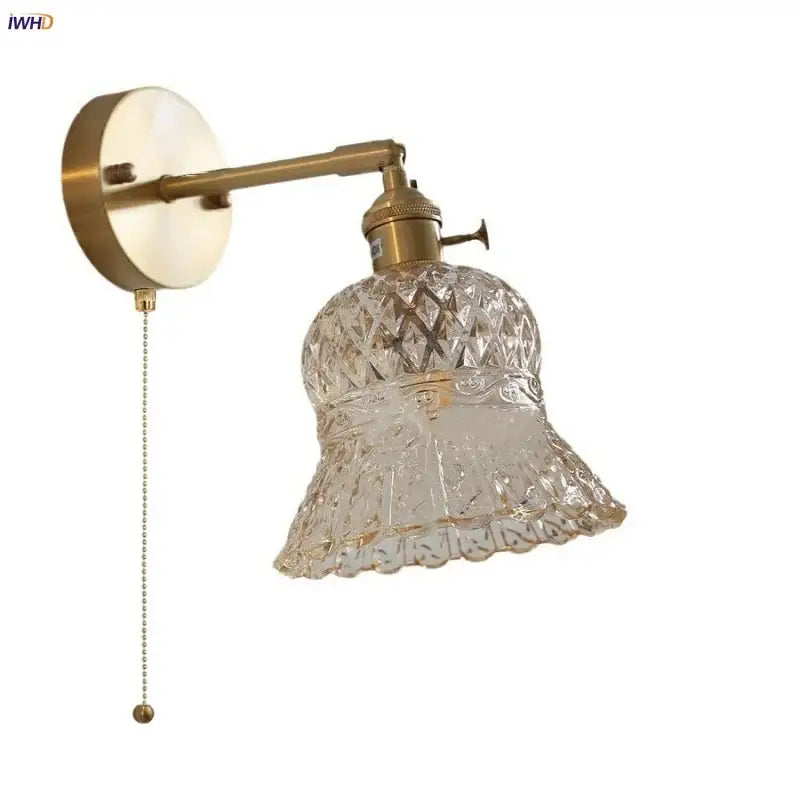 Brass finished wall light fixture with clear intricately cut amber flower crystal glass shade and attached pull chain