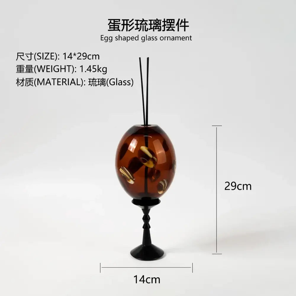 Translucent amber glass geometric circle reed diffuser shaped like an egg with embedded golden brown decorbites geometric circle elements