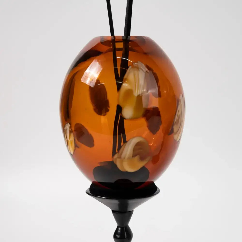 Amber geometric circle glass pendant with natural stone inclusions suspended from black cord for living room decorbites geometric circle decor
