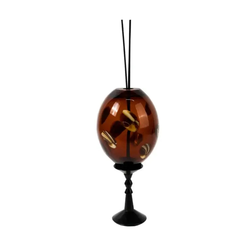 Amber geometric circle glass reed diffuser with golden butterfly decals and black stand for living room decor