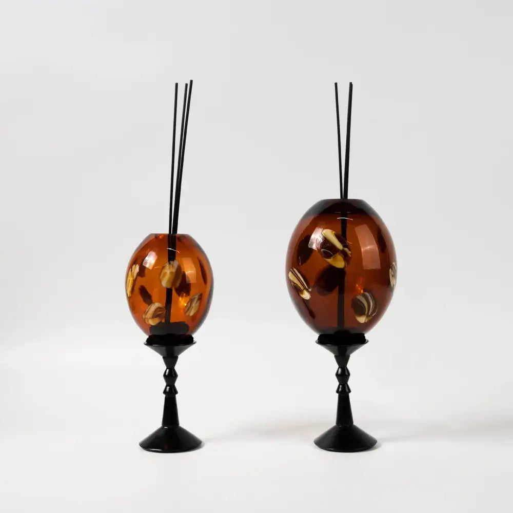 Amber geometric circle glass reed diffuser holders with gold-leaf shell inlays on black metal stands for living room decor