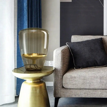 Gold-finished side table with a translucent amber glass led table lamp for modern bedroom lighting