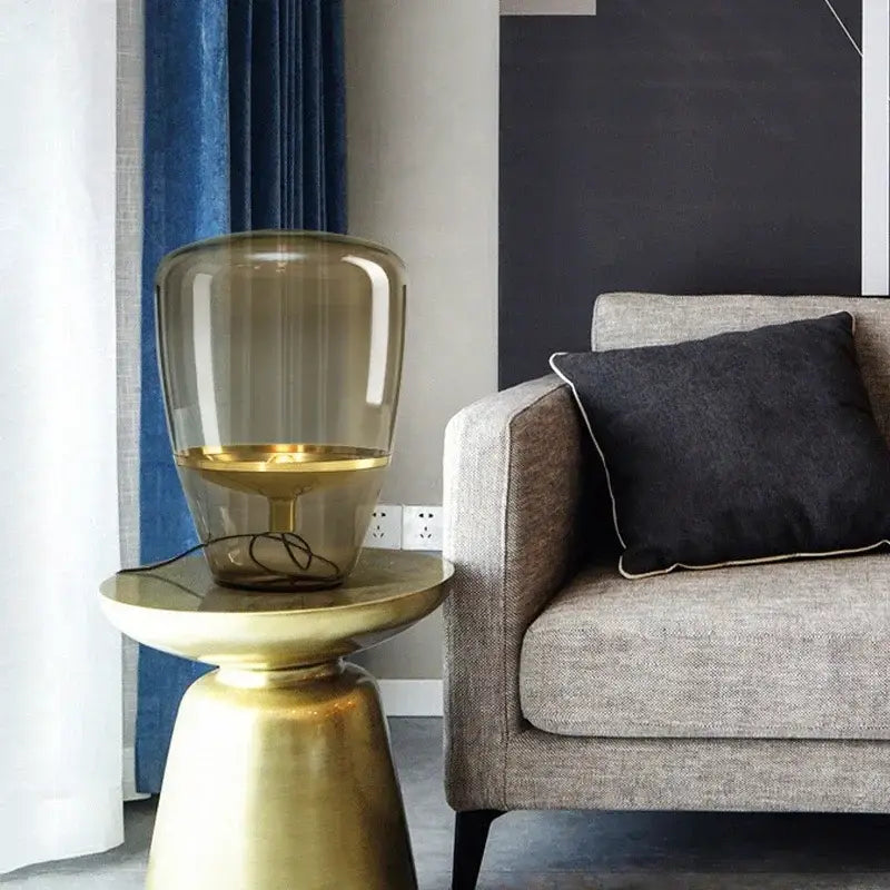 Gold-finished side table with a translucent amber glass led table lamp for modern bedroom lighting