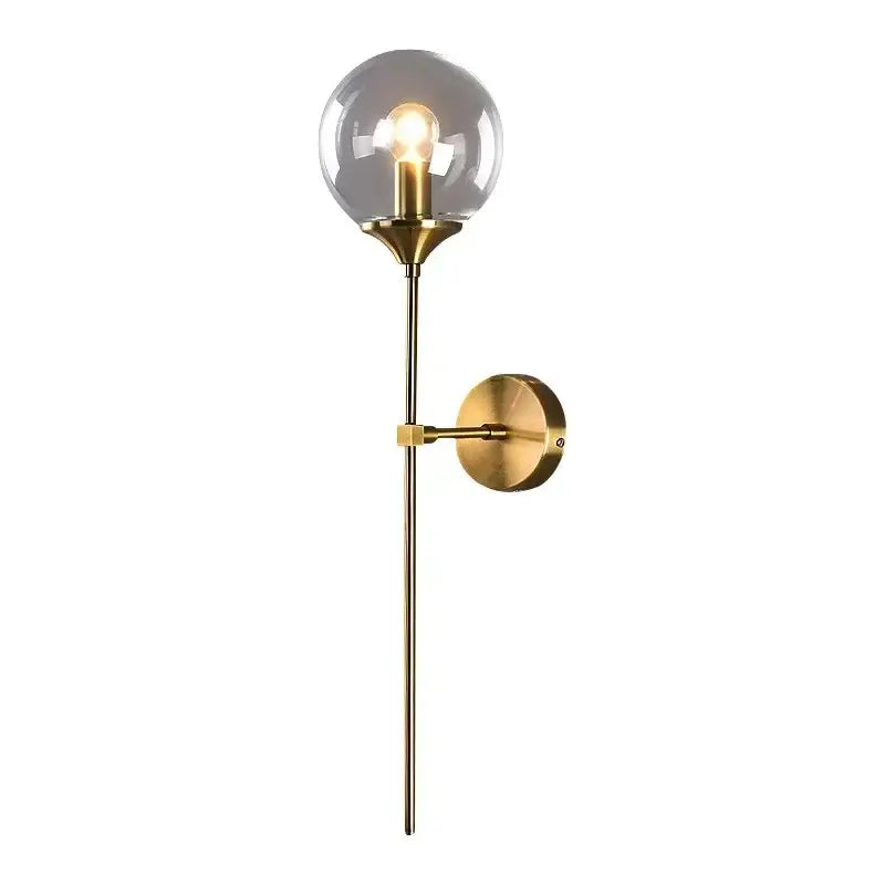 Brass finished sconce light with amber decorbites glass ball and exposed bulb, ideal for bedroom wall decor