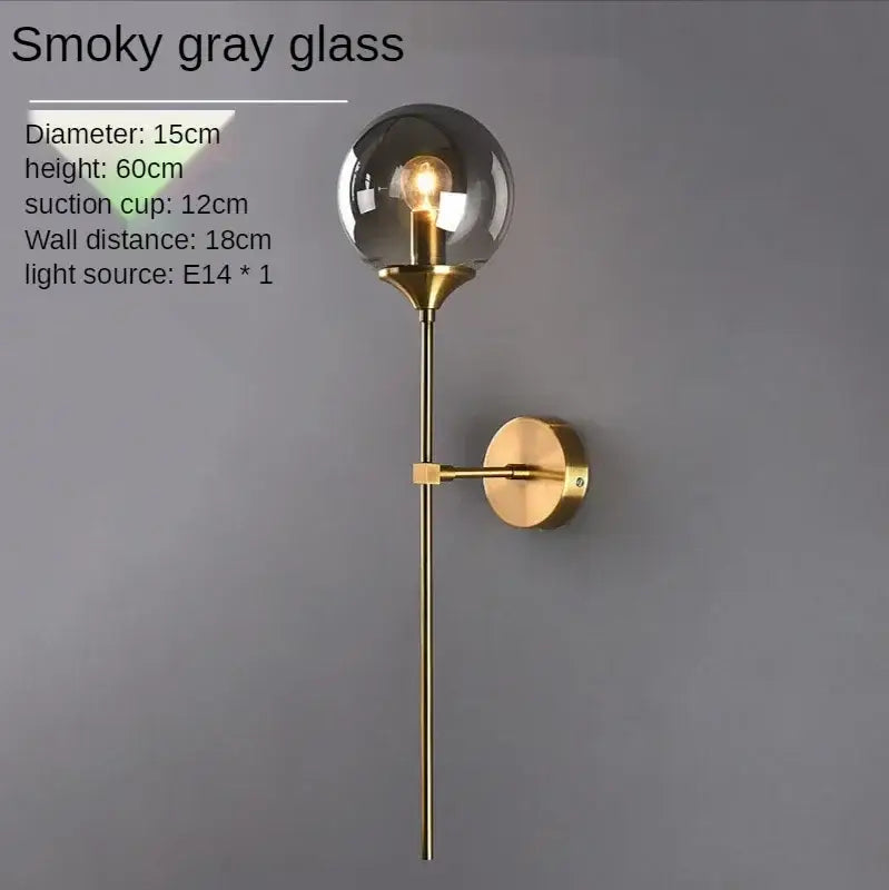 A sleek smoky gray glass ball sconce light with brass finish stem and bracket for bedroom decorbites glass ball decor