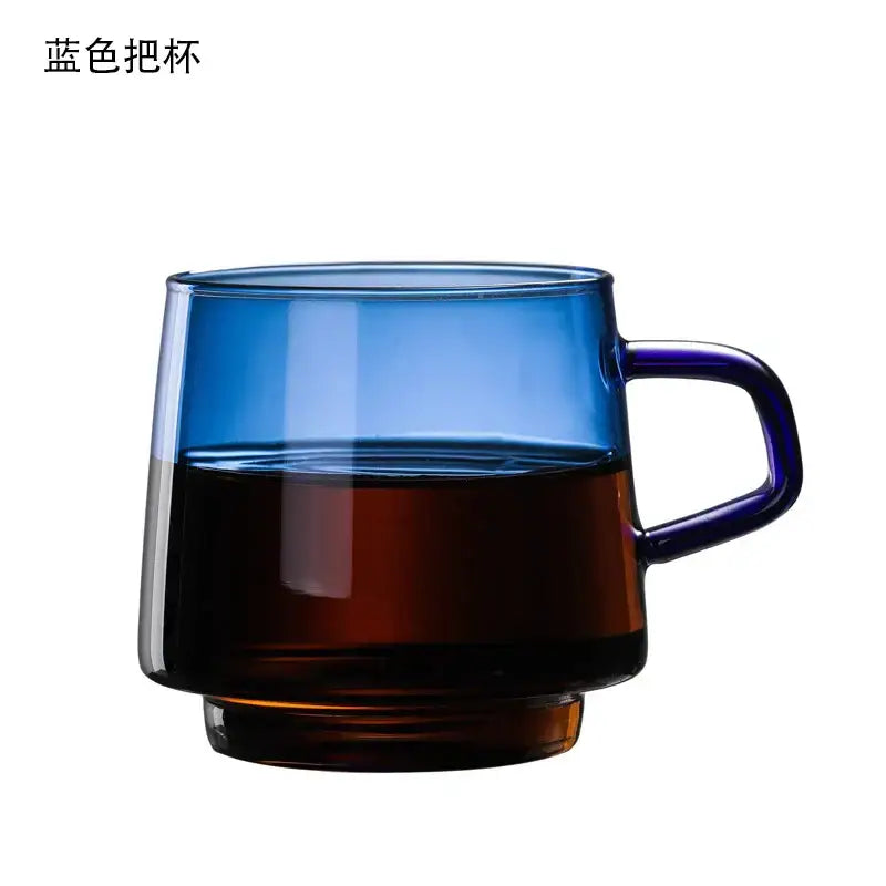 A translucent blue glass coffee mug with matching handle filled halfway with dark liquid from decorbites glass coffee collection