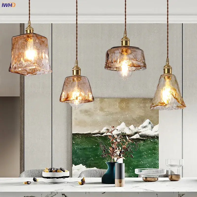 Four amber glass copper pendant lights with textured glass and brass fixtures hang from braided cords for dining room