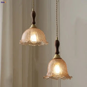 Two warm-toned amber glass led pendant lamps with dark wood accents and brass fittings for kitchen lighting