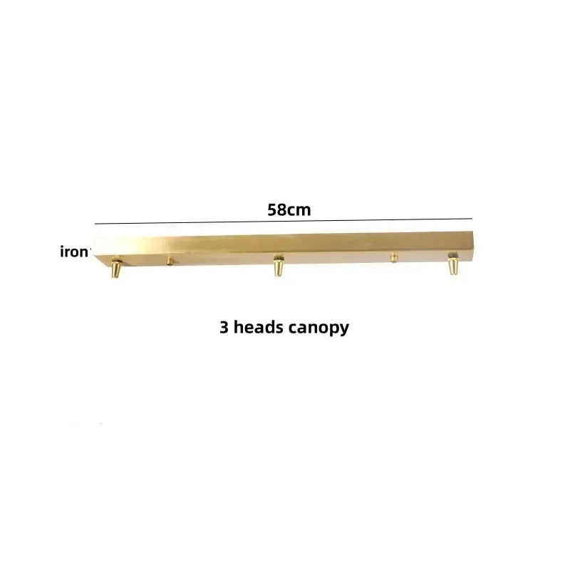 A brass-finished iron canopy 58cm long with three hooks for amber glass pendant light with decorbites brass knob switch