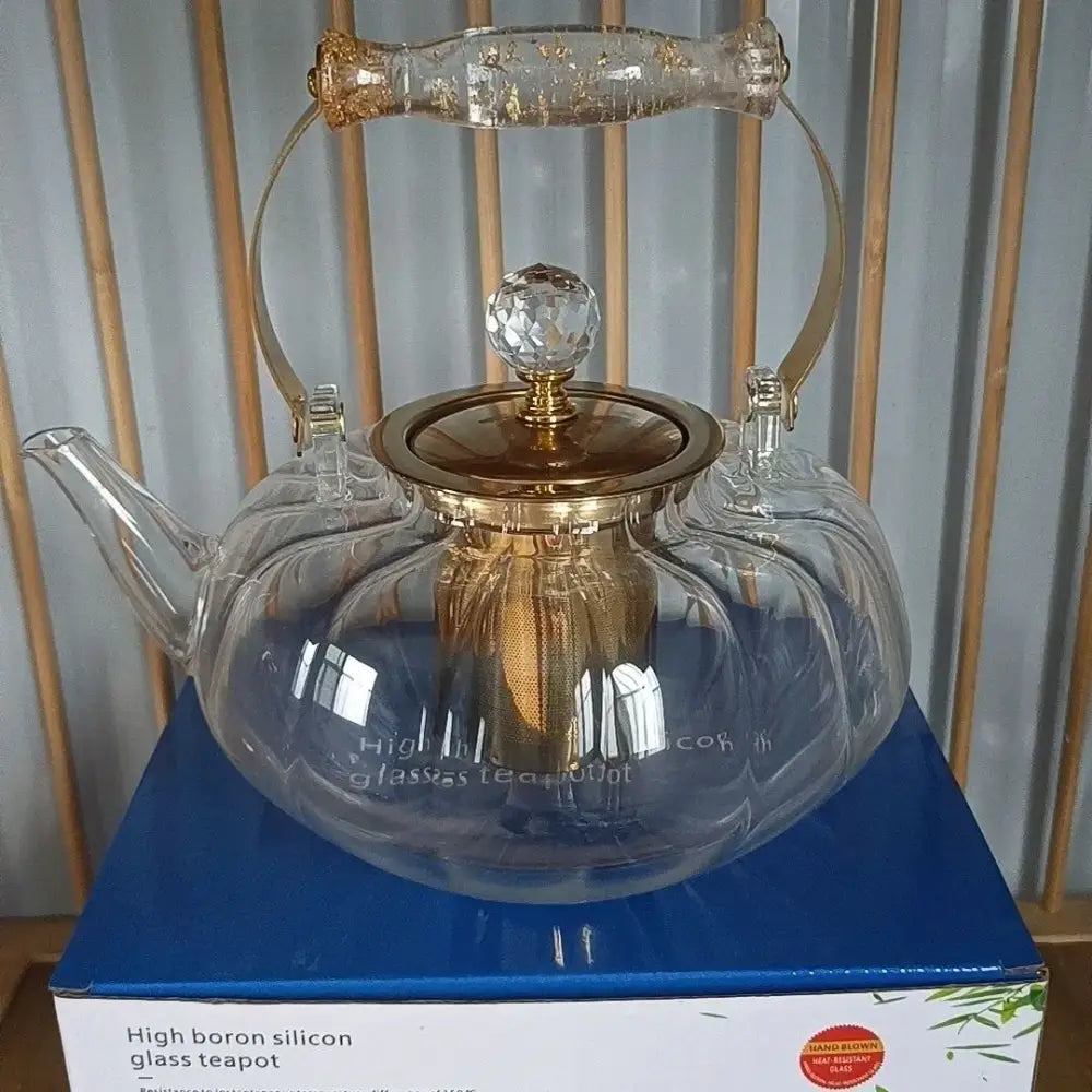Amber glass teapot with gold infuser features a clear glass body, gold-toned accents, and a crystal lid knob by decorbites