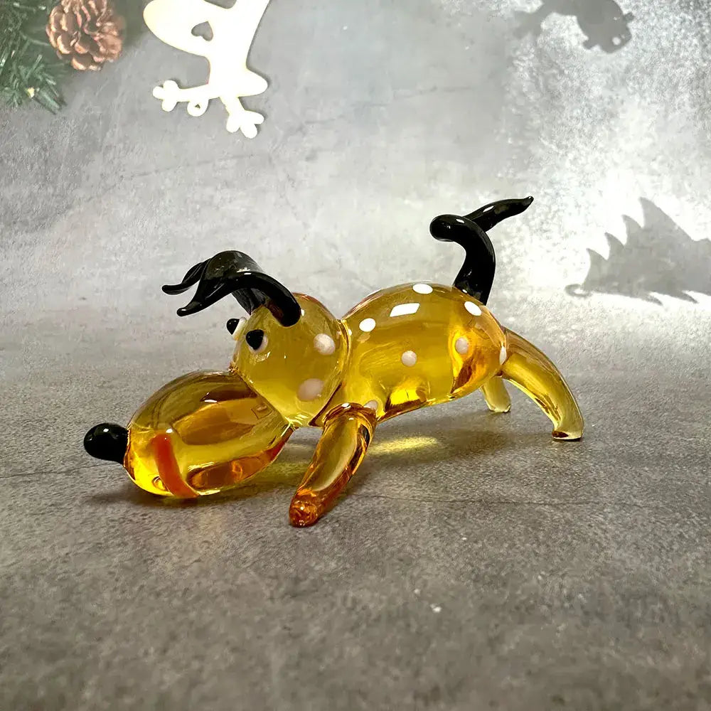 A translucent amber glass cartoon puppy figurine with black antlers and white spots for puppy figurine table decor