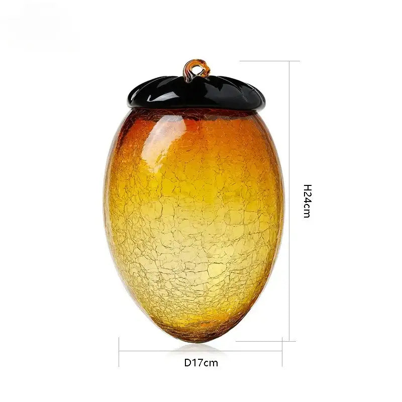 A translucent amber and orange glass hazelnut pinecone ornament with a crackled texture and gold hanging loop decorbites decor