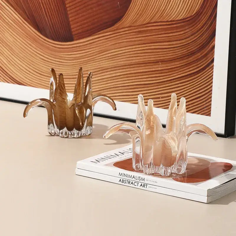 Two translucent amber and pale green glass petal candle holders with leaf-like arms and faceted bases for living room decor