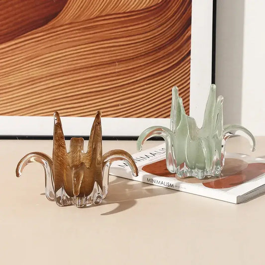 Two translucent glass petal candle holders in amber and pale green with sculpted leaf-like arms for living room decor